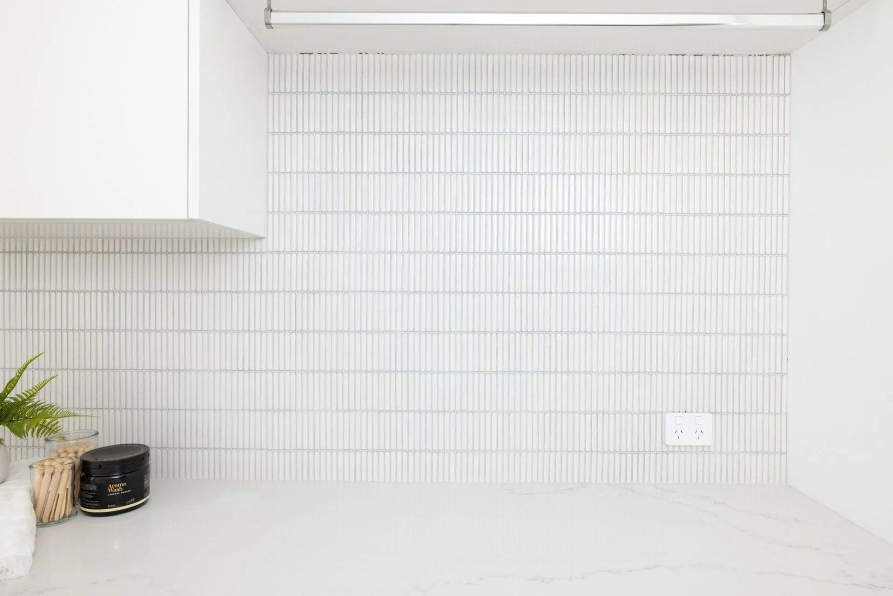A Laundry Room with White Tiles and A Clothesline Hanging from The Ceiling — Blue Horizon Projects in Tumbi Umbi, NSW
