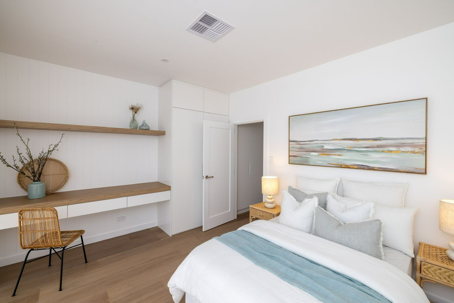 A Bedroom with A Bed, Desk, Chair and Painting on The Wall — Blue Horizon Projects in Wyong, NSW