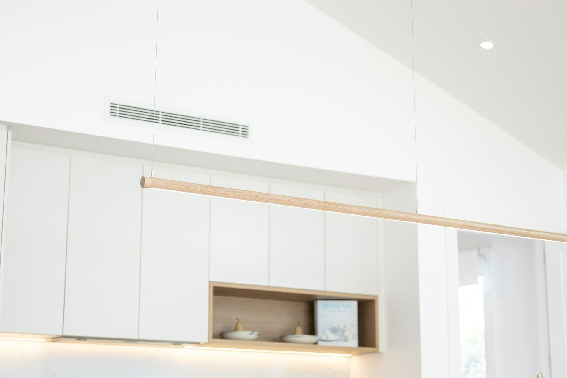 A Kitchen with White Cabinets and A Wooden Shelf — Blue Horizon Projects in Shelly Beach, NSW