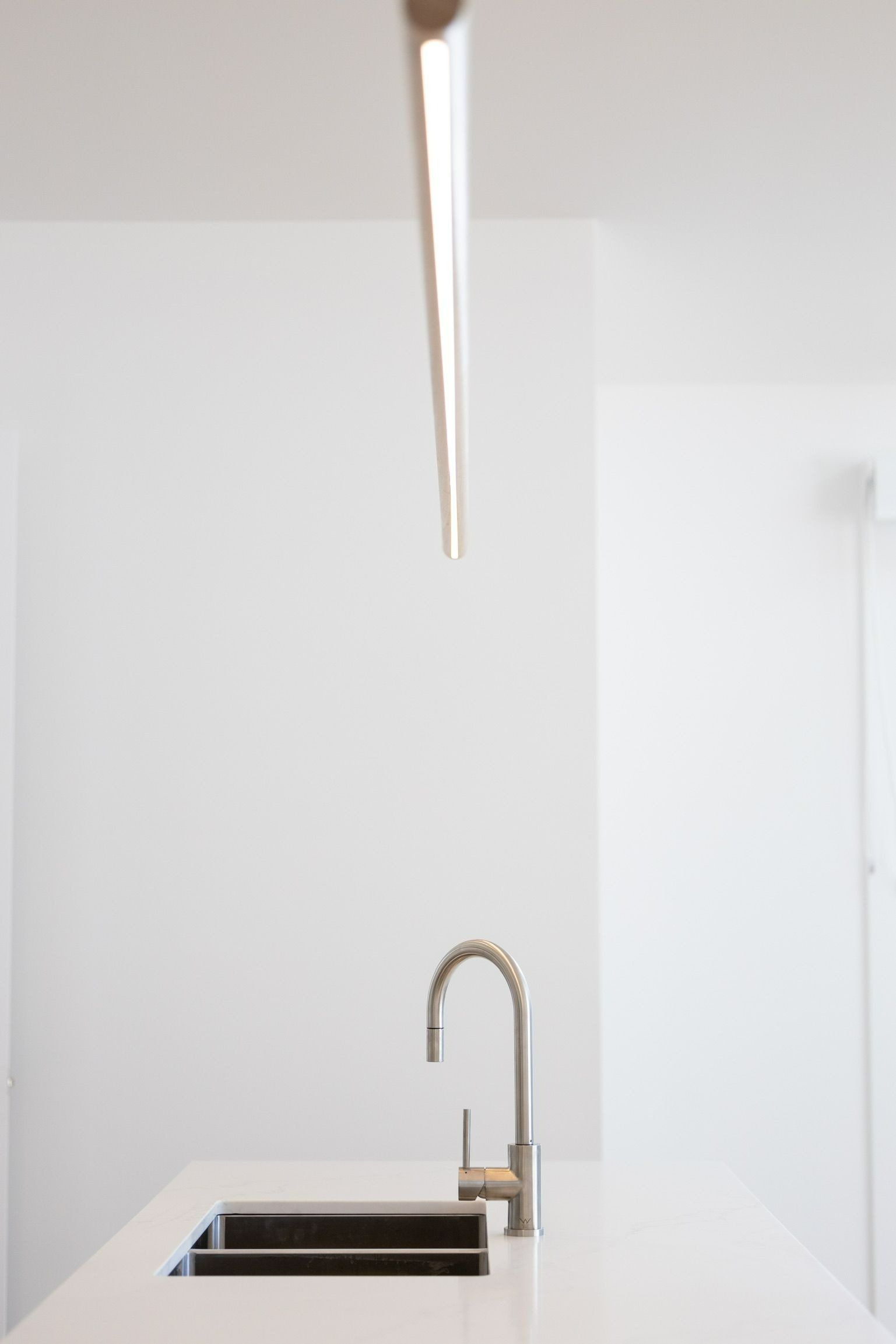 A Kitchen Sink with A Faucet and A Light Hanging from The Ceiling — Blue Horizon Projects in Shelly Beach, NSW