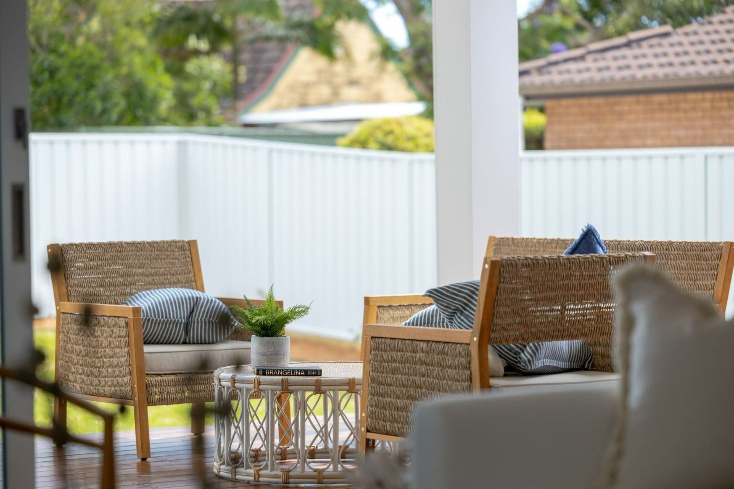 A Patio with Wicker Furniture and A Table — Blue Horizon Projects in Shelly Beach, NSW