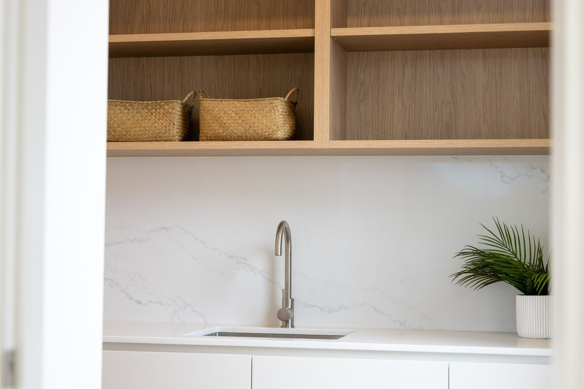 A Laundry Room with A Sink, Shelves and Baskets — Blue Horizon Projects in Shelly Beach, NSW