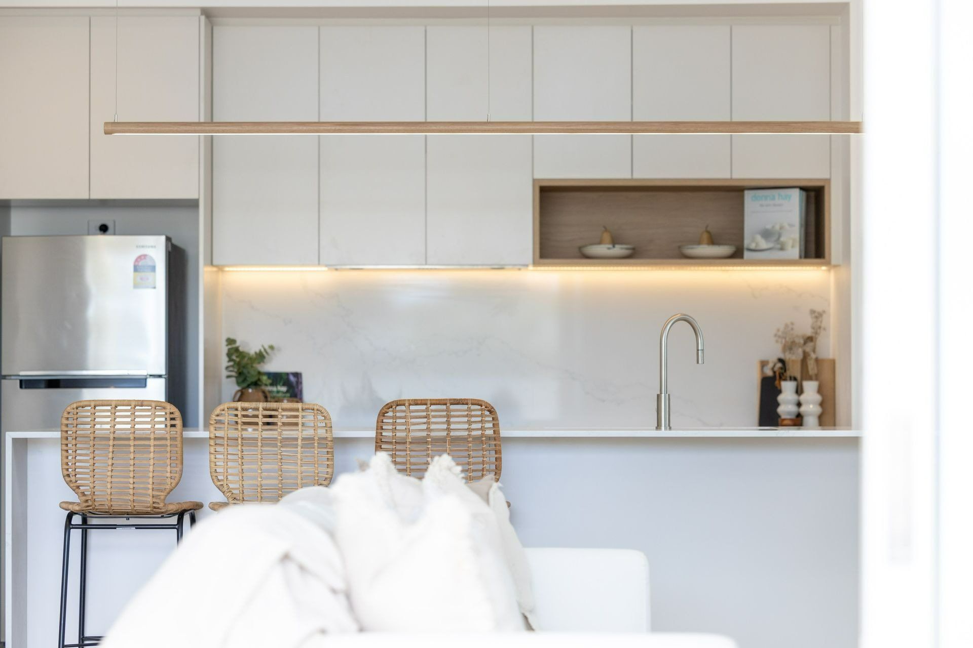 A Kitchen with White Cabinets and A Stainless Steel Refrigerator — Blue Horizon Projects in Blue Bay, NSW