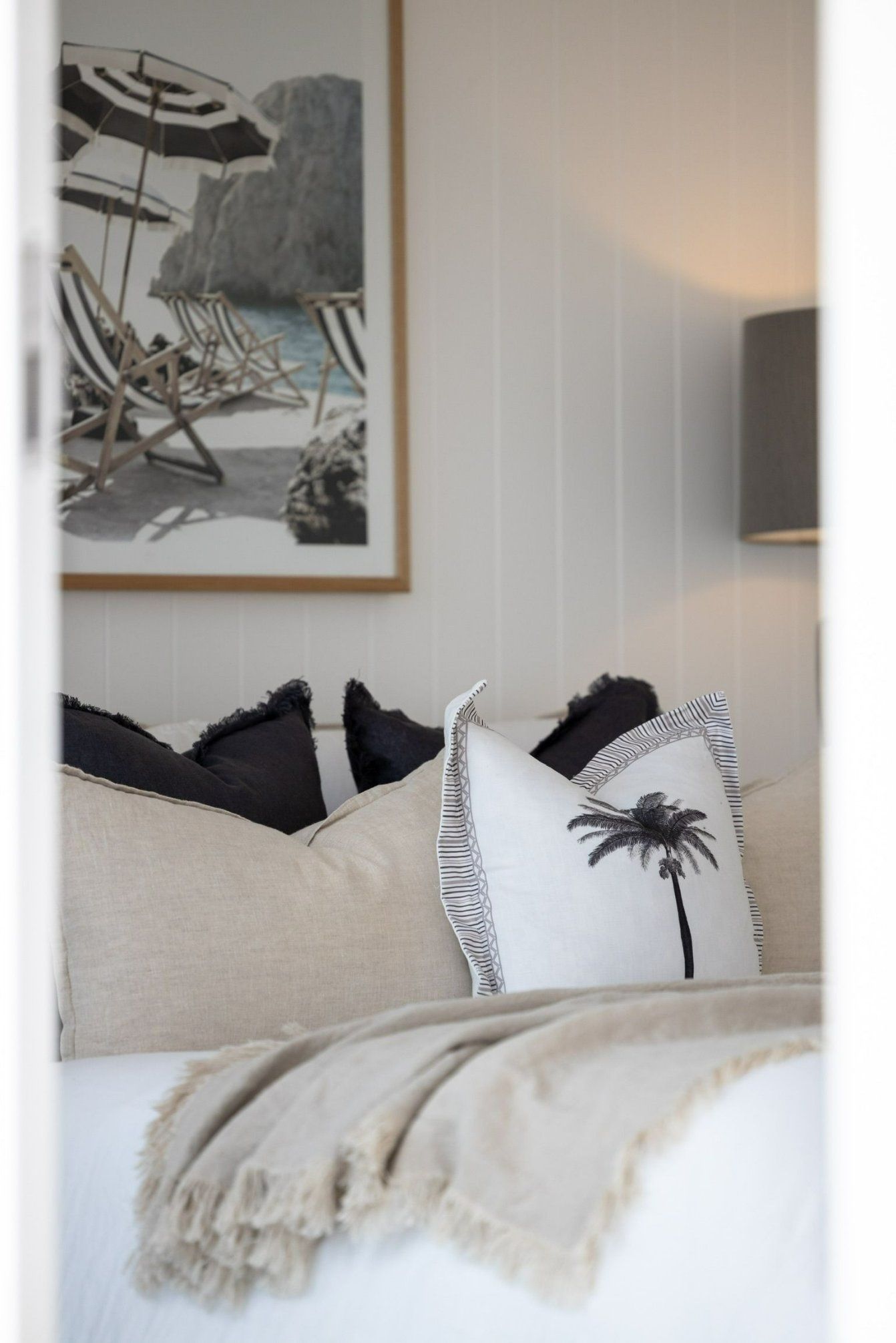 A Bedroom with A Bed , Pillows , a Lamp and A Picture on The Wall — Blue Horizon Projects in Blue Bay, NSW