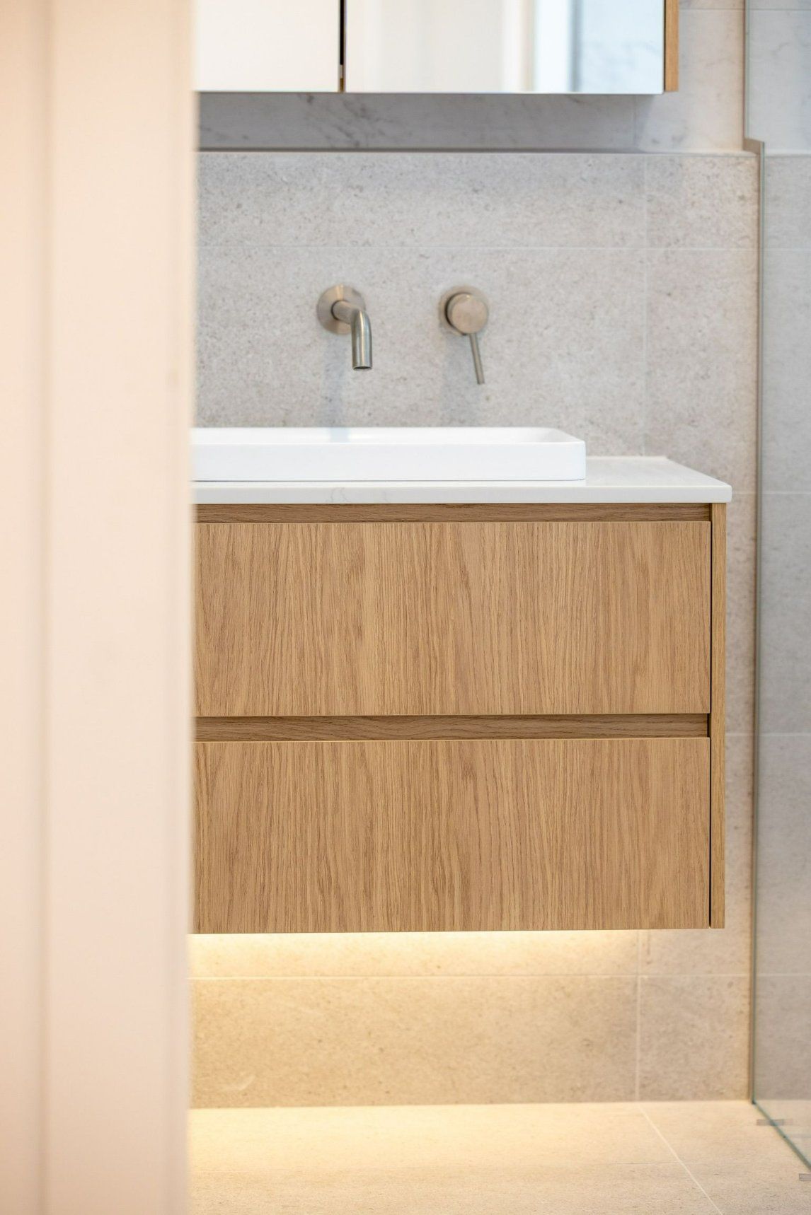 A Bathroom with A Sink, Mirror and Wooden Cabinets — Blue Horizon Projects in Blue Bay, NSW