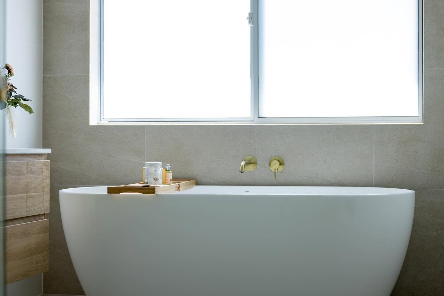 Minimalist Bathroom With A White Freestanding Tub Beneath A Frosted Window — Blue Horizon Projects in Berkeley Vale, NSW
