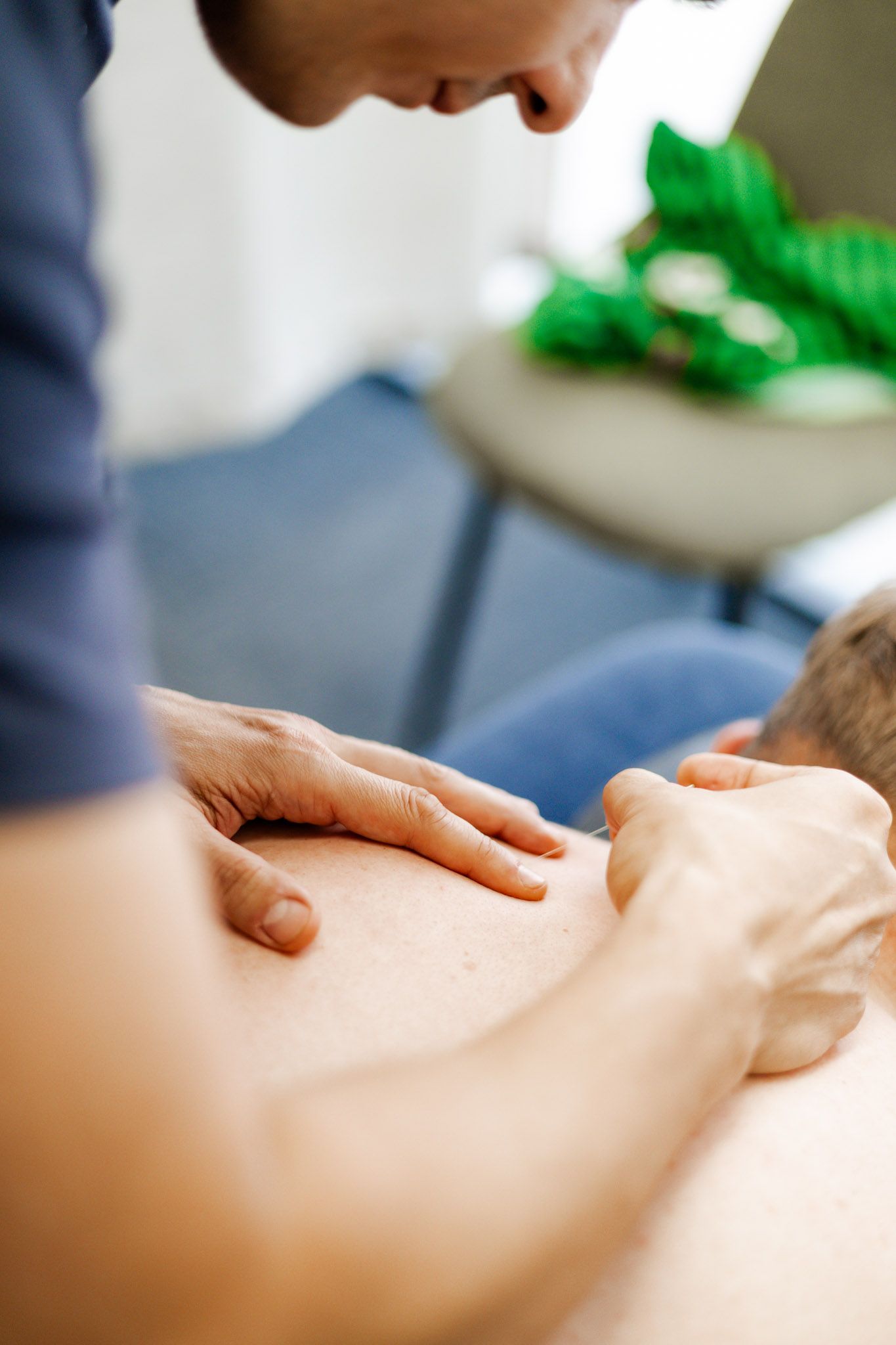 Person giving a back massage. Hands on a bare back. Soft lighting.