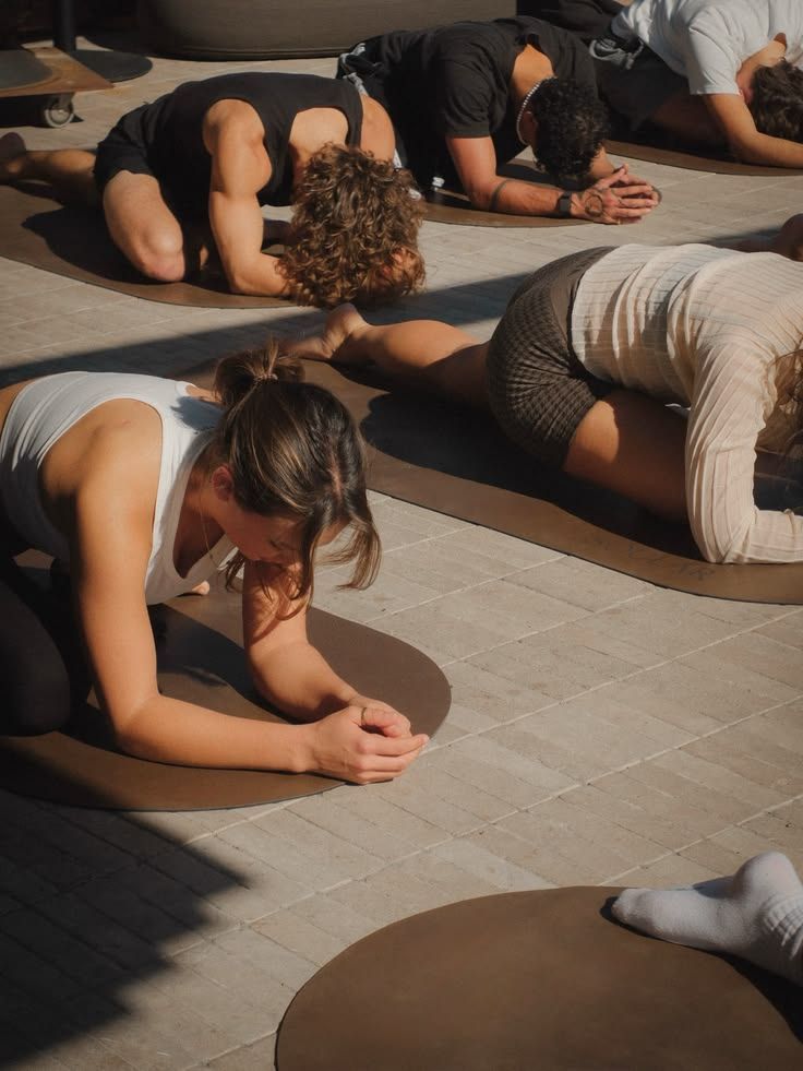 Person holding a black dumbbell while kneeling on a gym floor