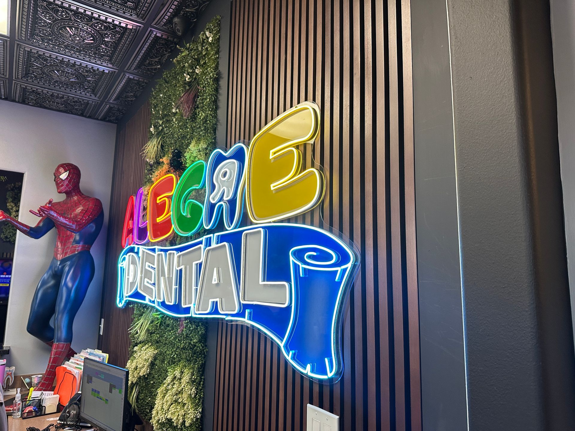 Spider-Man figure beside colorful “MEGA DIGITAL” neon sign in a modern indoor display area