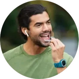 Young man smiling with earbuds, showing clear aligners