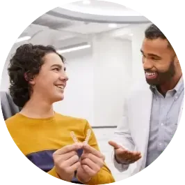 Orthodontist talking with teenage patient about Invisalign