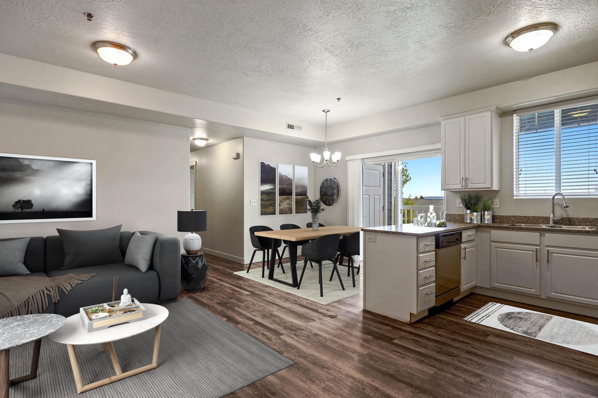 a living room with a couch , table , chairs and a kitchen .