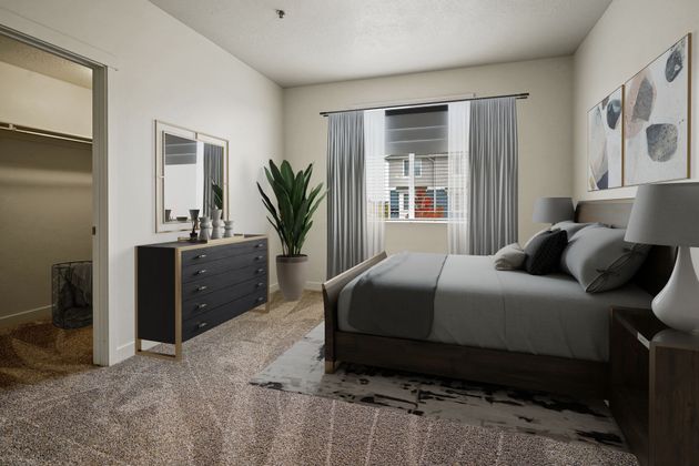 a bedroom with a bed , dresser , mirror and a walk in closet .
