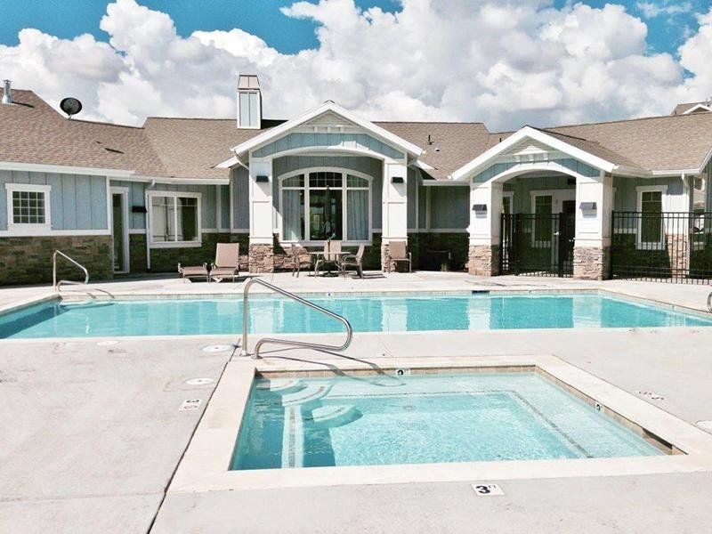 a house with a swimming pool and a hot tub in front of it