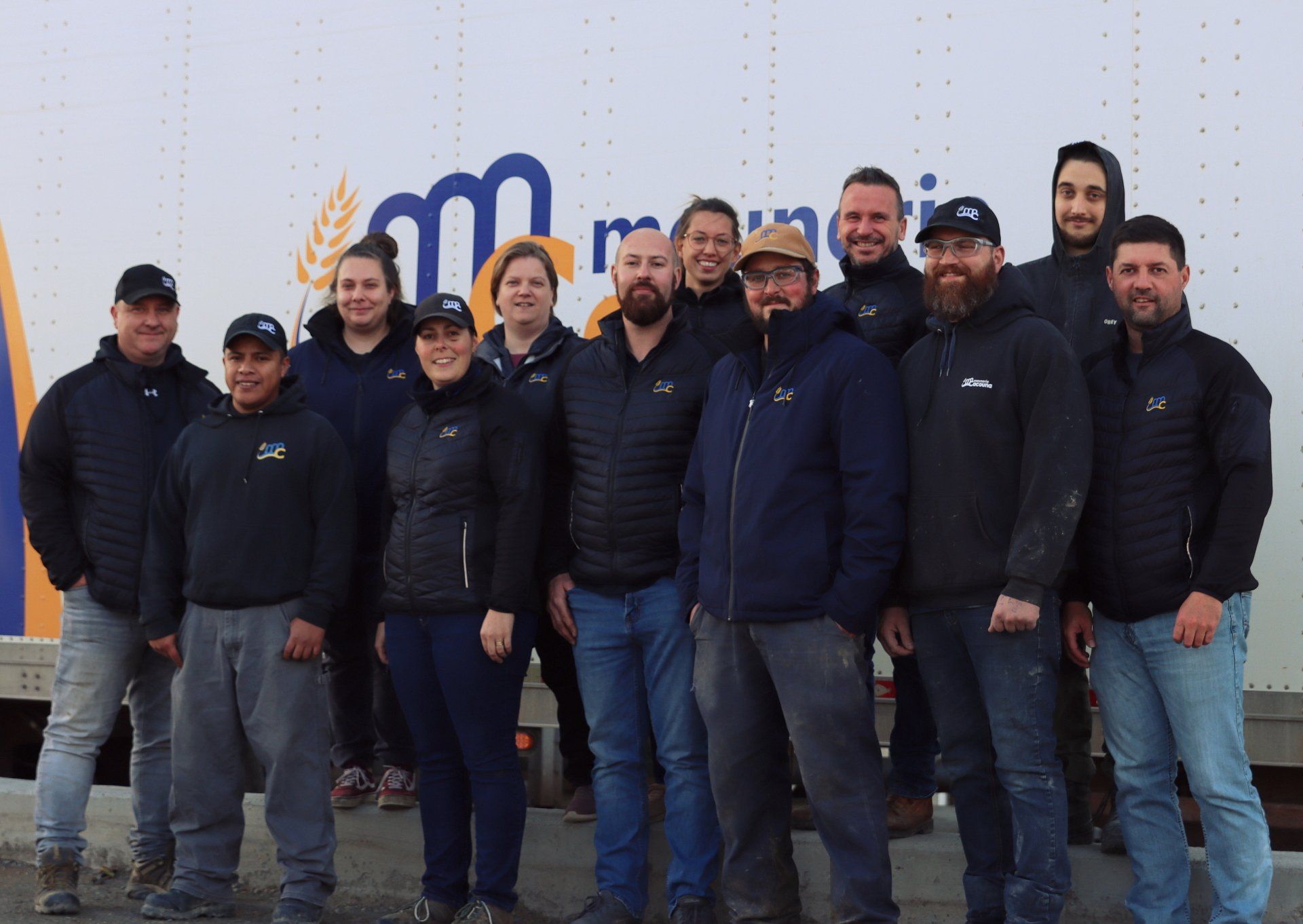 Un groupe de personnes pose pour une photo devant un camion.