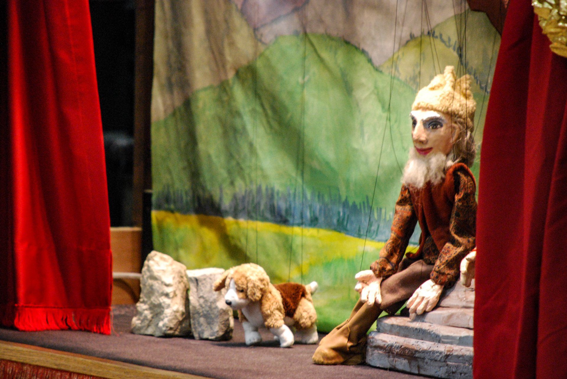 Rustic marionette sitting on large rock