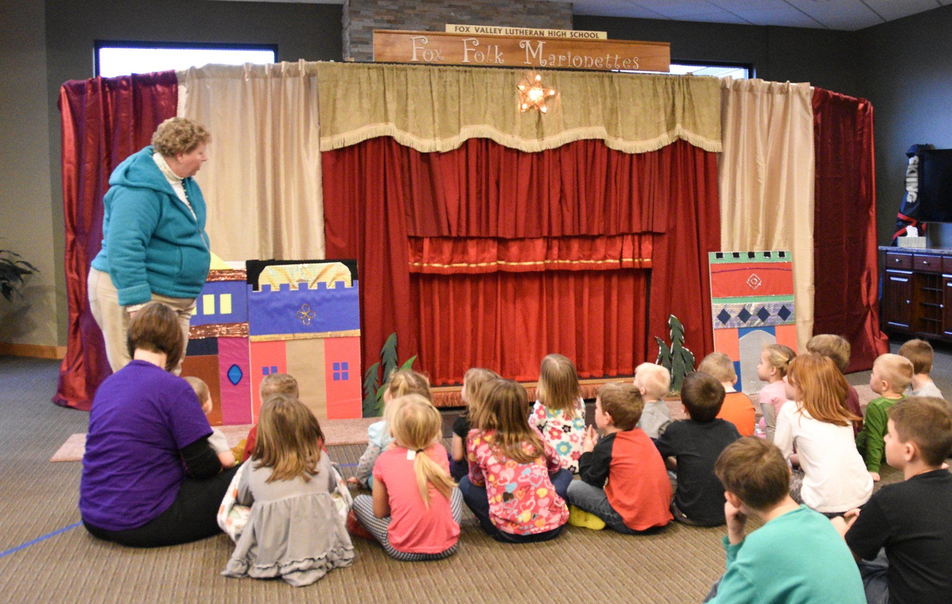 young audience members await the opening of the curtain