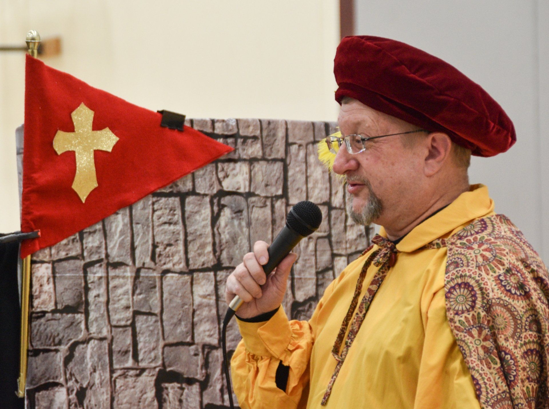 Mr. Dave in his minstrel costume uses a mic to communicate with the audience