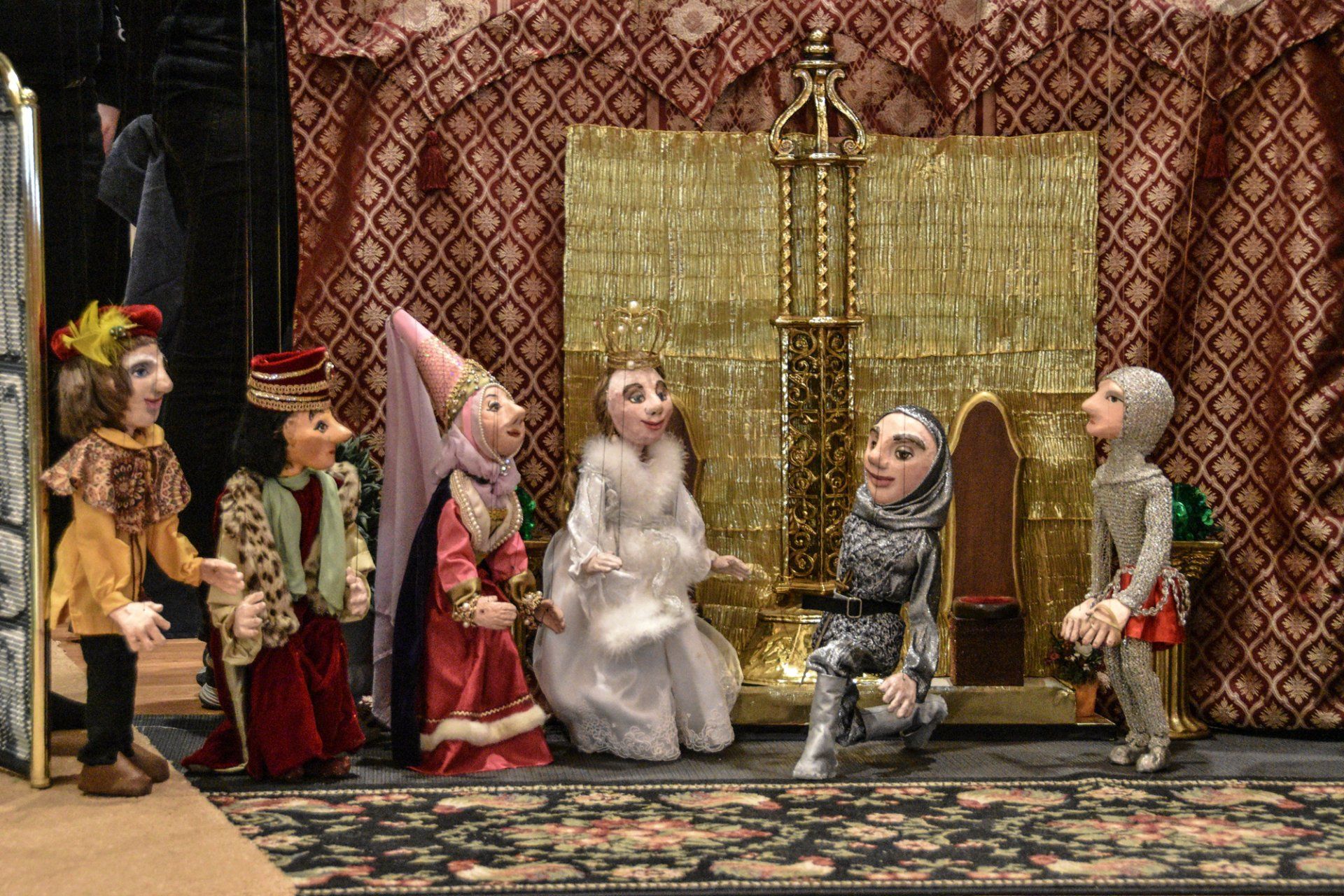The brave knight kneels before the Queen and the Princess in the Royal Court
