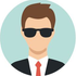 Avatar d’une personne portant des lunettes de soleil, un costume et une cravate rouge, sur un fond circulaire bleu clair