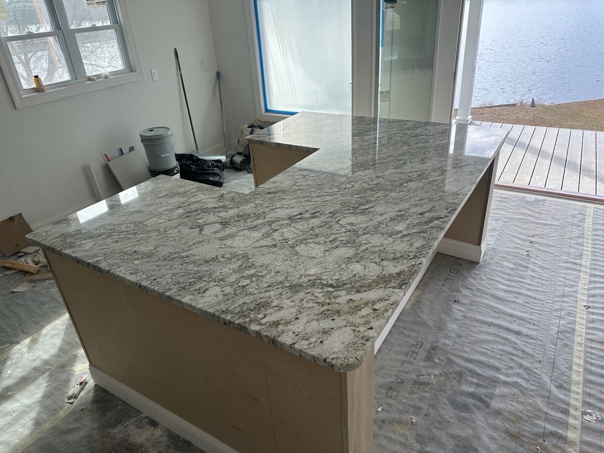 Kitchen island with speckled granite countertop in an unfinished room near a sliding glass door