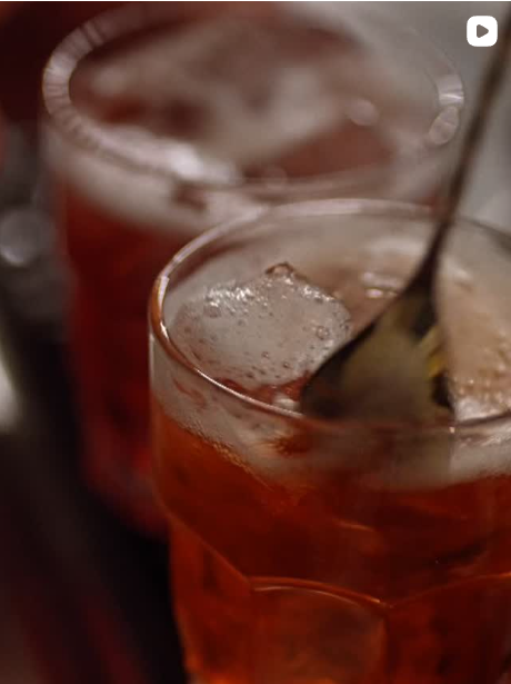 Due bicchieri di bevanda rossa ghiacciata con un cucchiaino nel bicchiere anteriore.