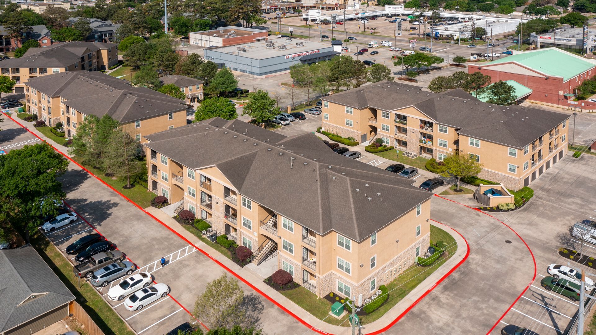 Aerial view of The Lexington at Champions Apartments featuring multi-story apartment buildings, resident parking, and landscaped grounds in Houston, TX.