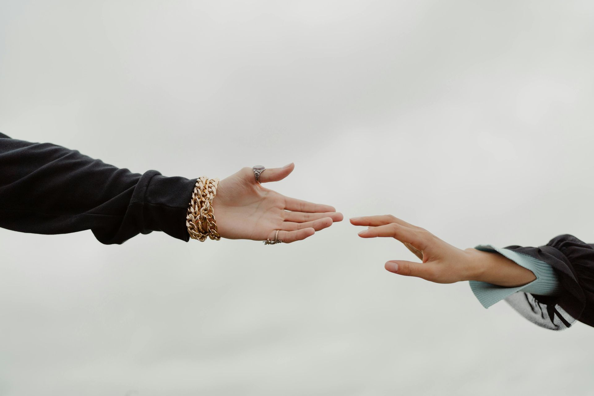 Two people are reaching out to each other 's hands.