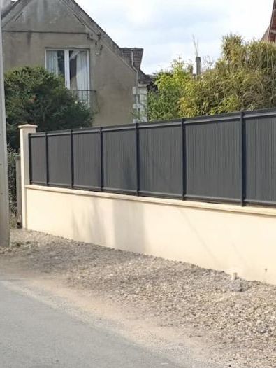 Un mur blanc est en train d’être construit au milieu d’un champ de terre.