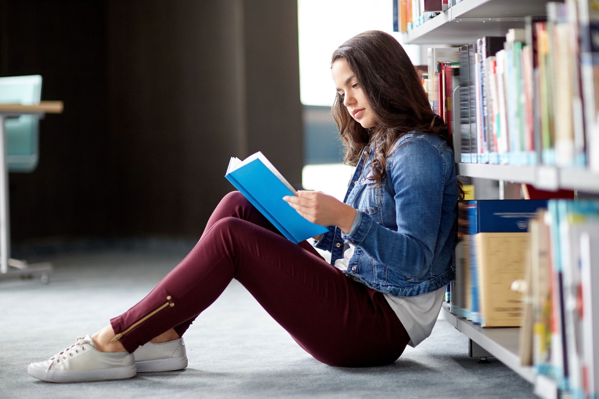 WOMAN READING BOOK ON FLOOR