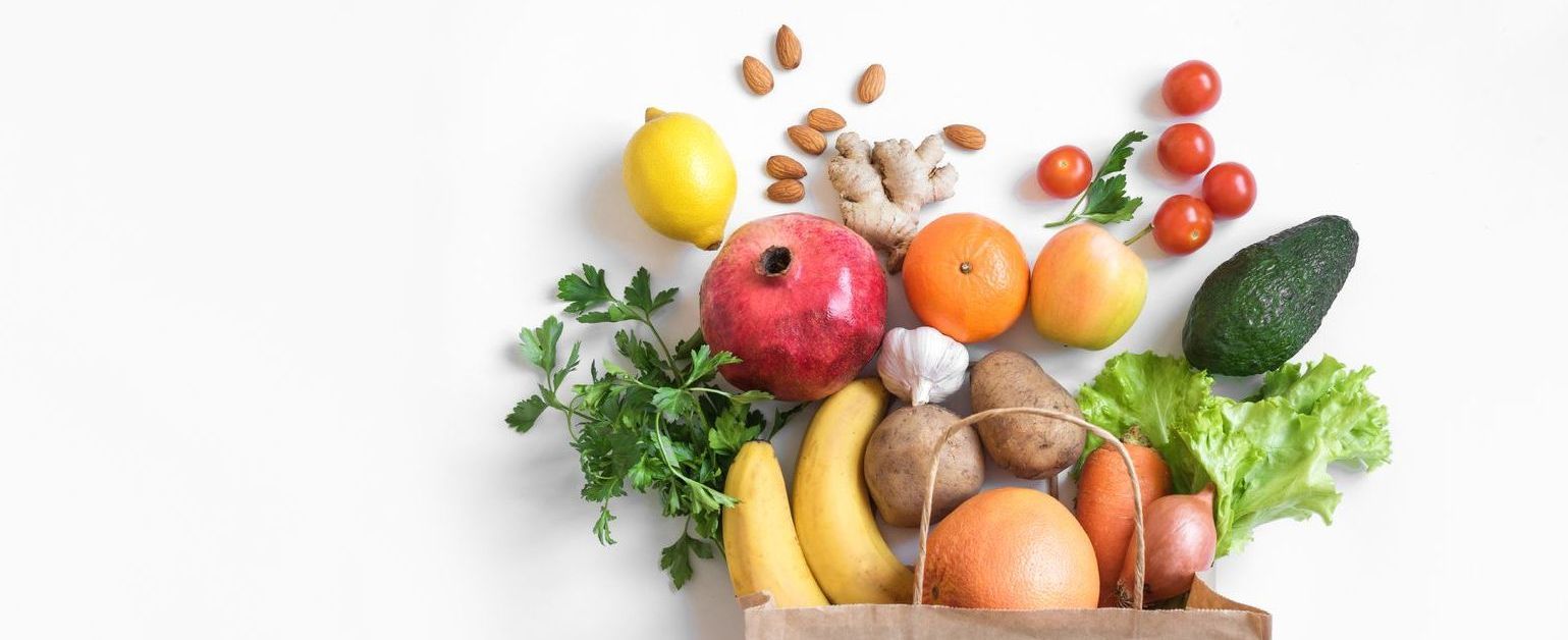 a paper bag spilling out fresh produce.