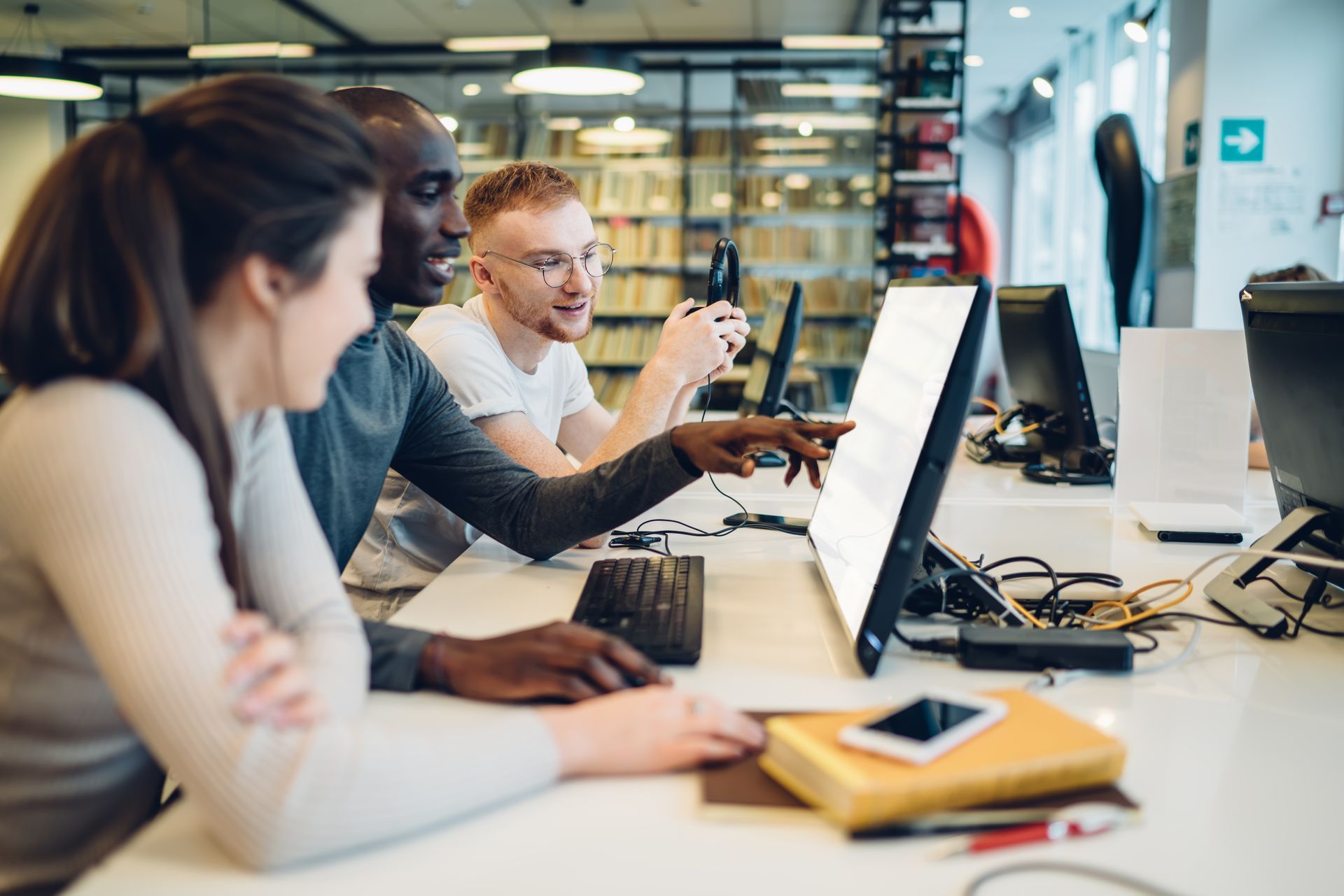 Photo of three people looking a computer monitor.