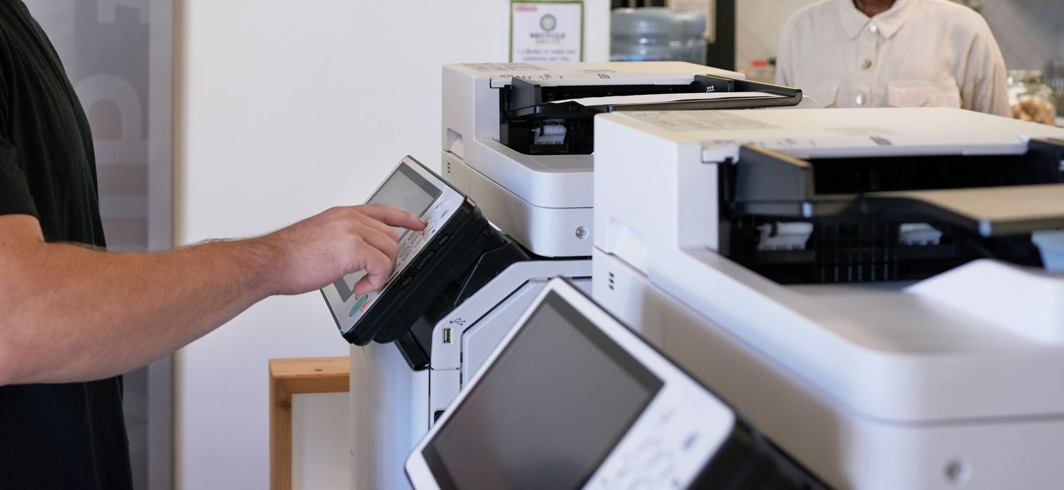 Close up of a person's arm using a copier.