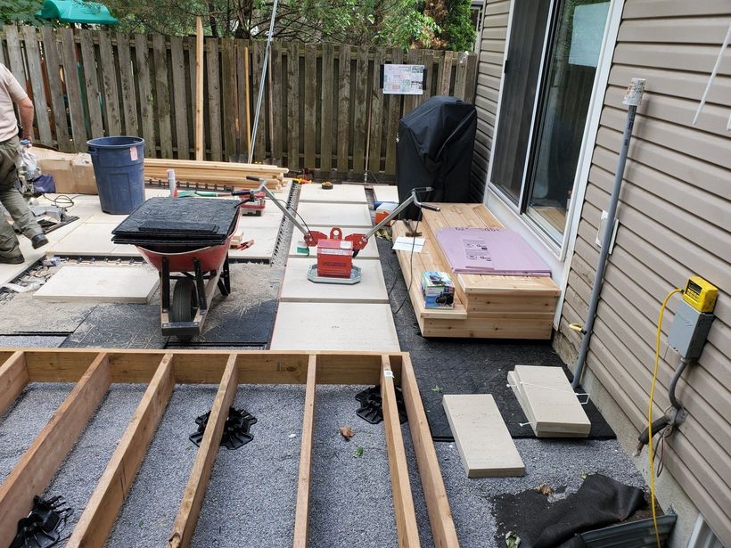 A wheelbarrow is sitting on top of a wooden deck under construction.