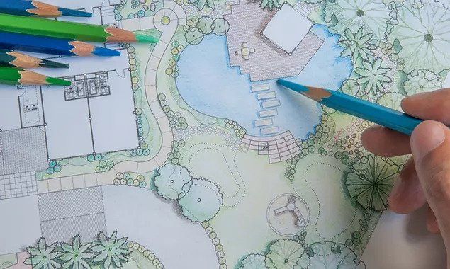 A person is drawing a garden with colored pencils