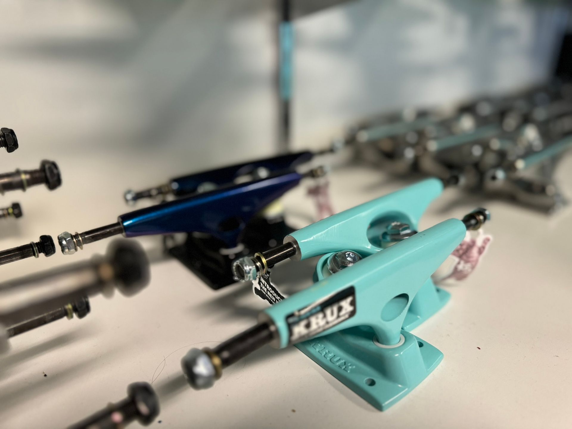 Turbocharger actuation arms in turquoise and black, arranged on a tabletop in a workshop.