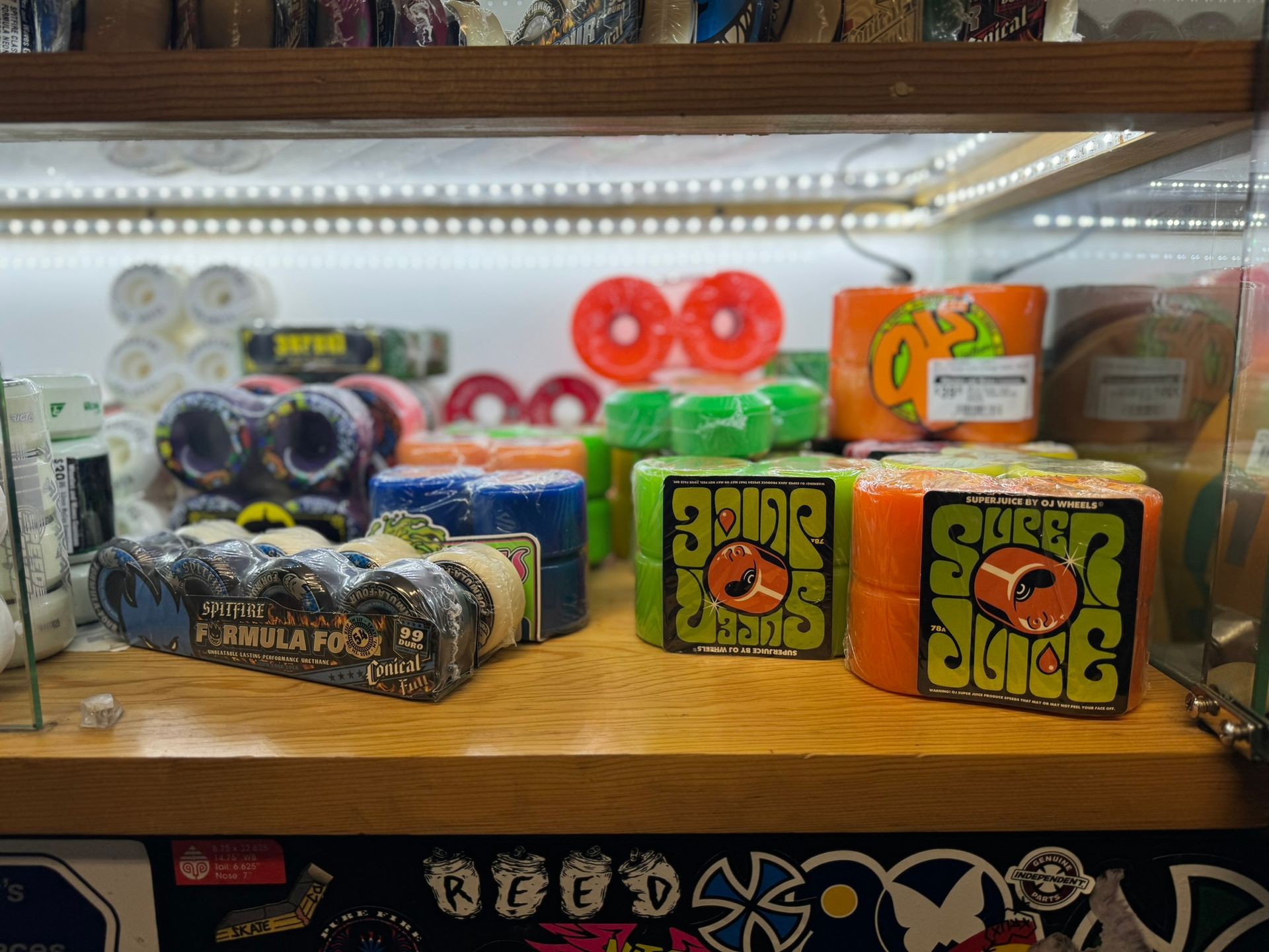 Assorted colorful rolls and boxes of stickers or tape on a lit shelf display