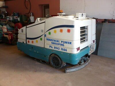 Industrial power sweeper, white and teal, with company logo and phone number, inside a garage — Industrial Power Sweeping Services Pty Ltd In Knuckey Lagoon, NT