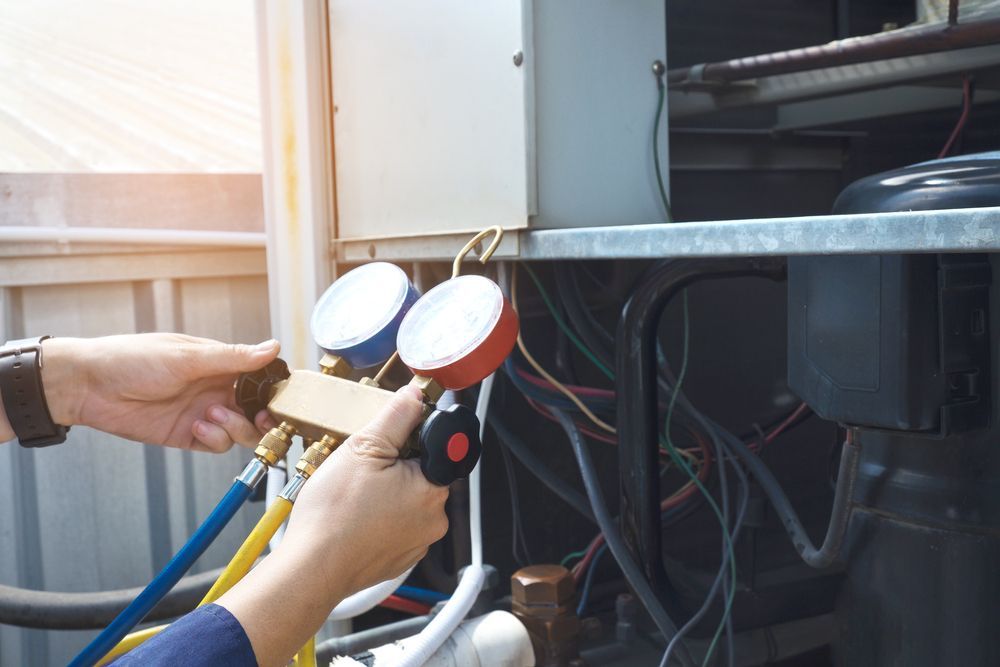 A Person Is Working On An Air Conditioner With Gauges — Law Air Conditioning In Townsville, QLD