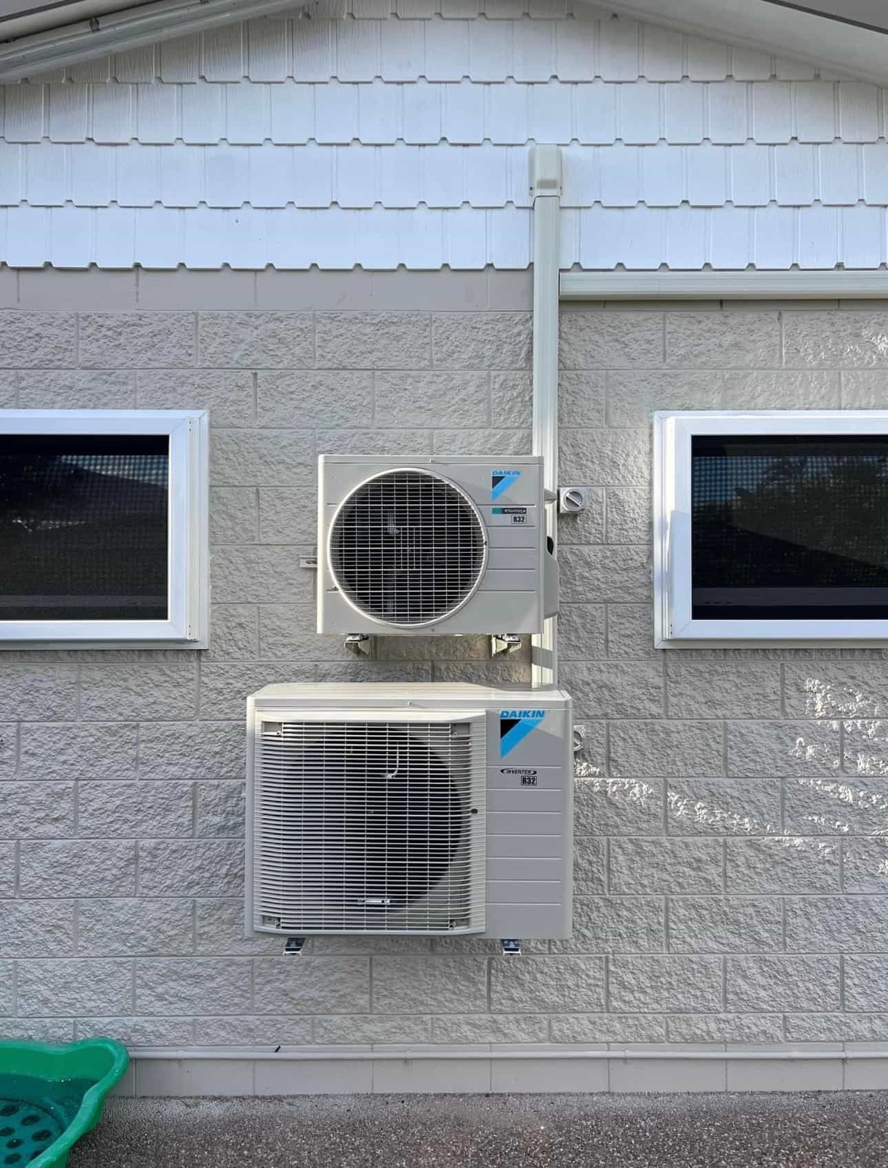 Two air conditioners are mounted on the side of a building — Law Air Conditioning In Townsville, QLD