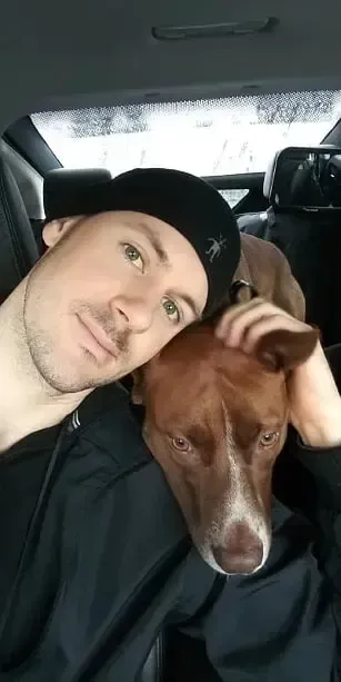A man and his dog are sitting in the back seat of a car