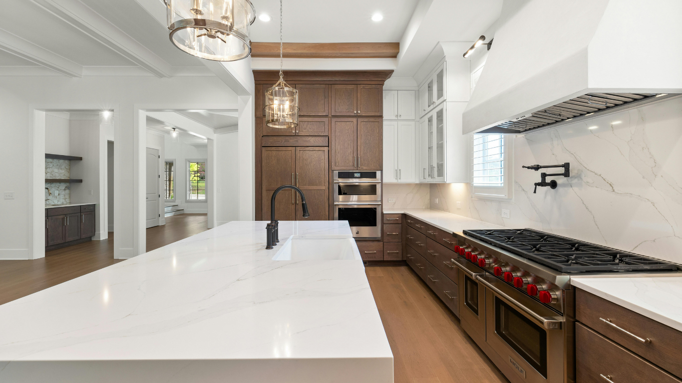 White kitchen island with quartz countertop and black cabinet hardware.
