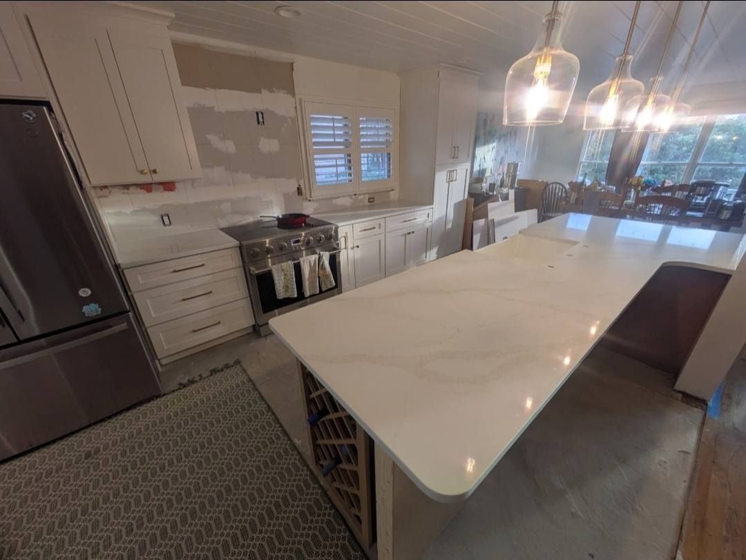 Bright modern kitchen with a large white island, stainless appliances, and pendant lights