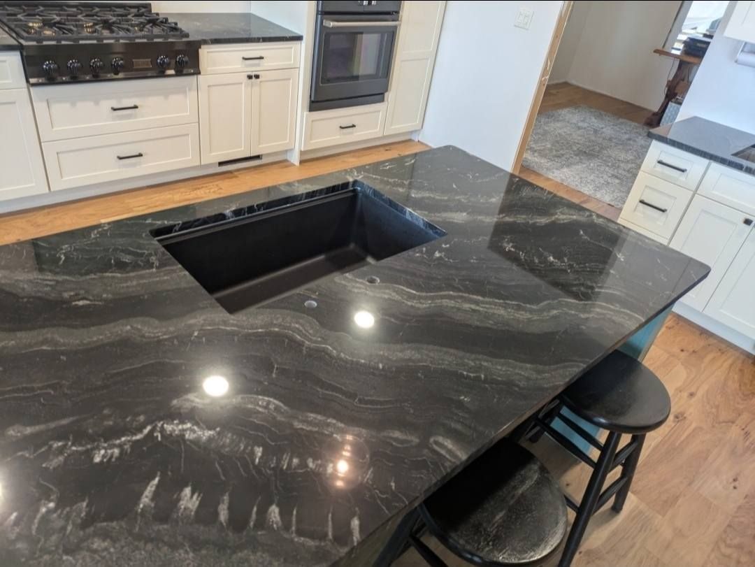 Black marble kitchen island with built-in sink in a modern kitchen