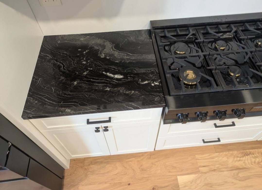 Burnt black cooktop and countertop beside a gas stove in a kitchen