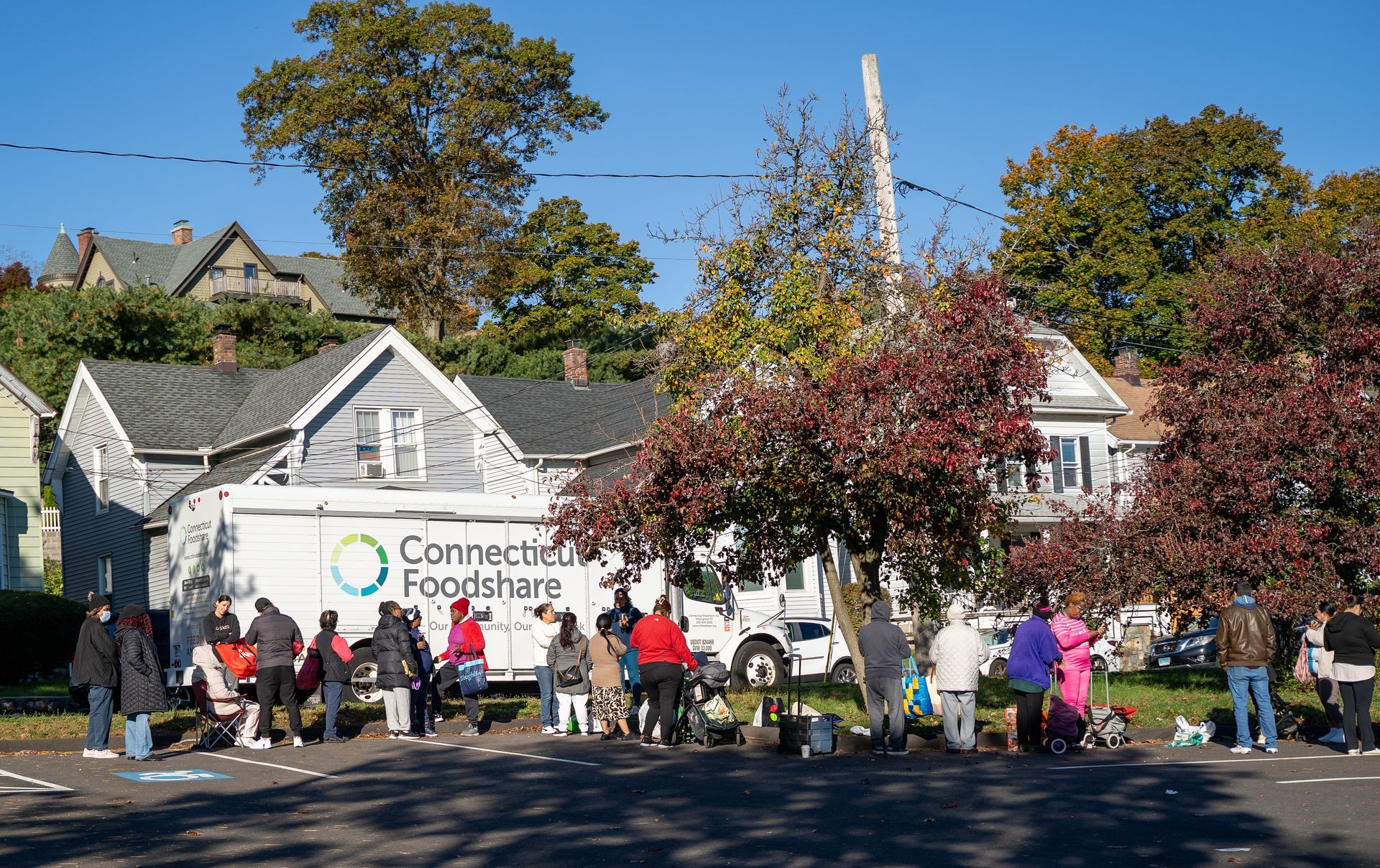 Neighbors wait in line for the Connecticut Foodshare mobile food pantry in Norwalk to begin.