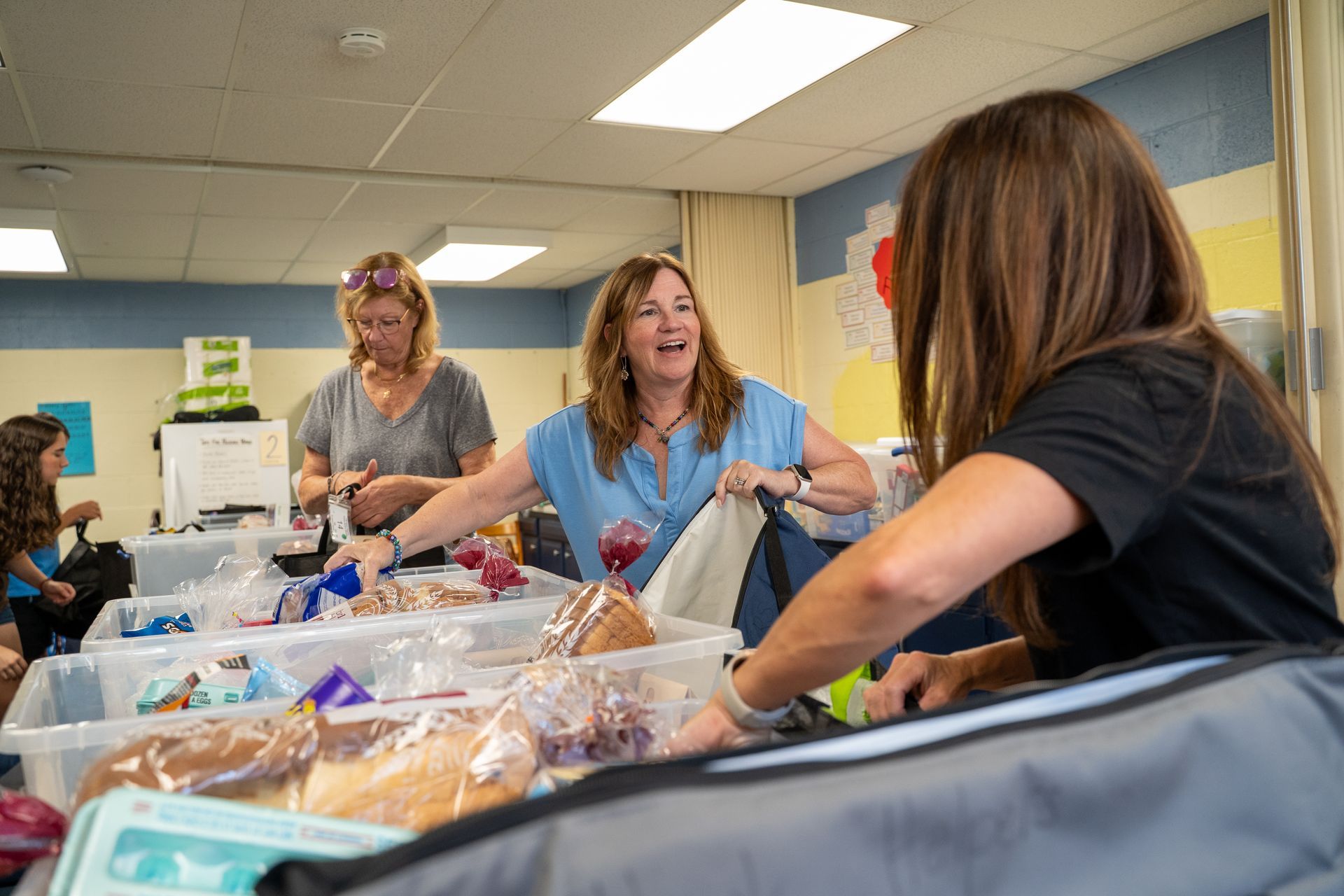 volunteers pack food for a school backpack program