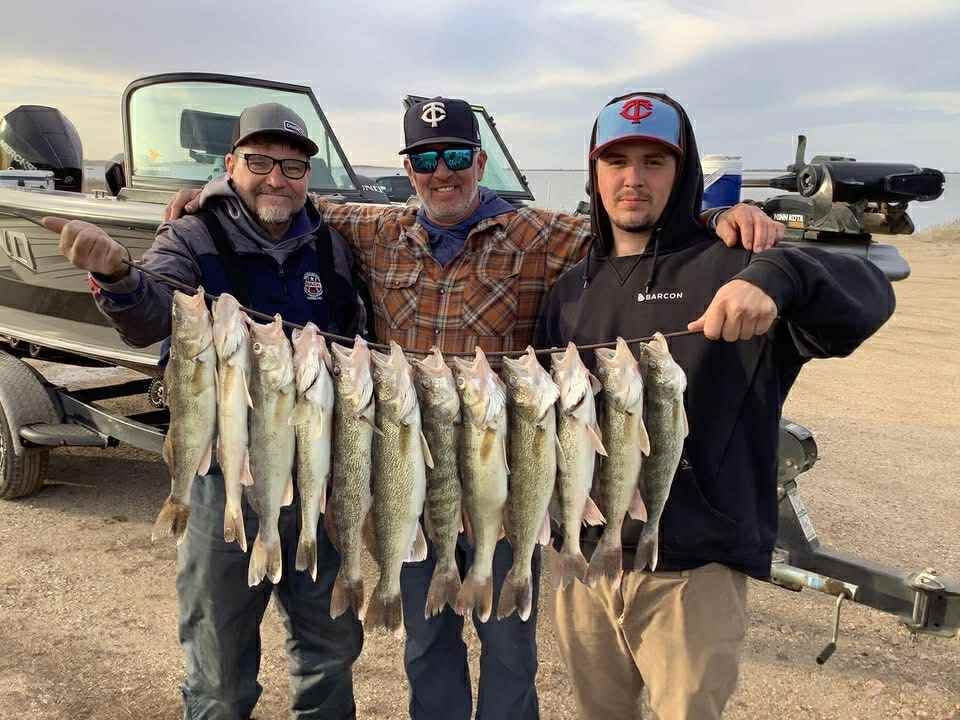 Man in boat on Lake Thompson, holding large walleye