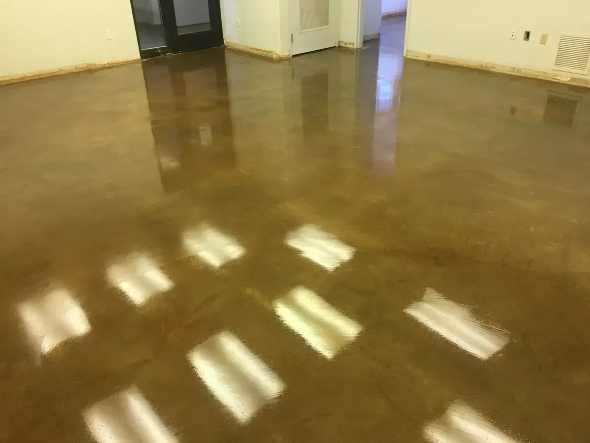 Shiny, reflective brown floor in a room, with light reflections.