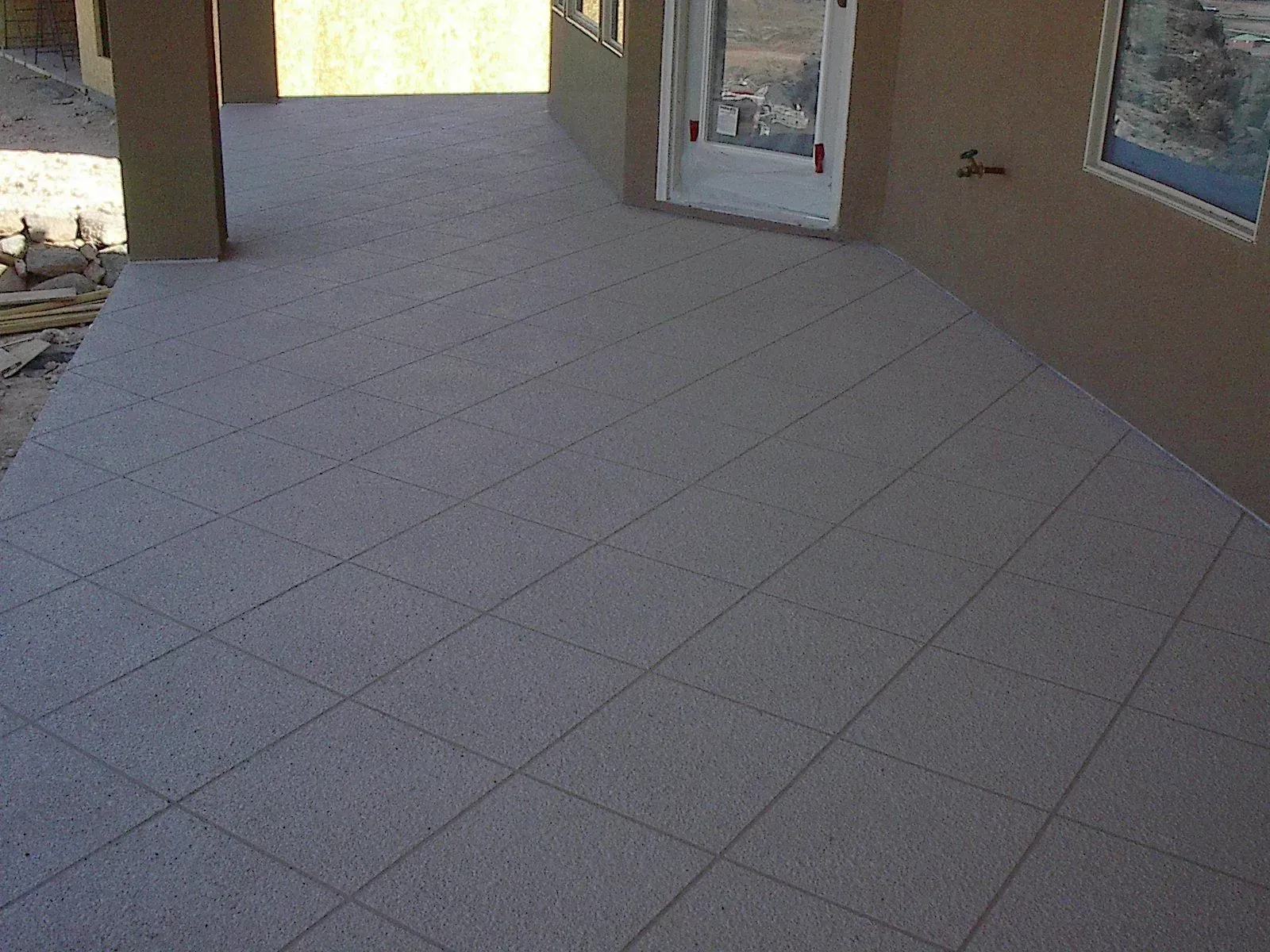 Concrete patio with diagonal grid pattern; neutral colors, sunny outdoor setting.